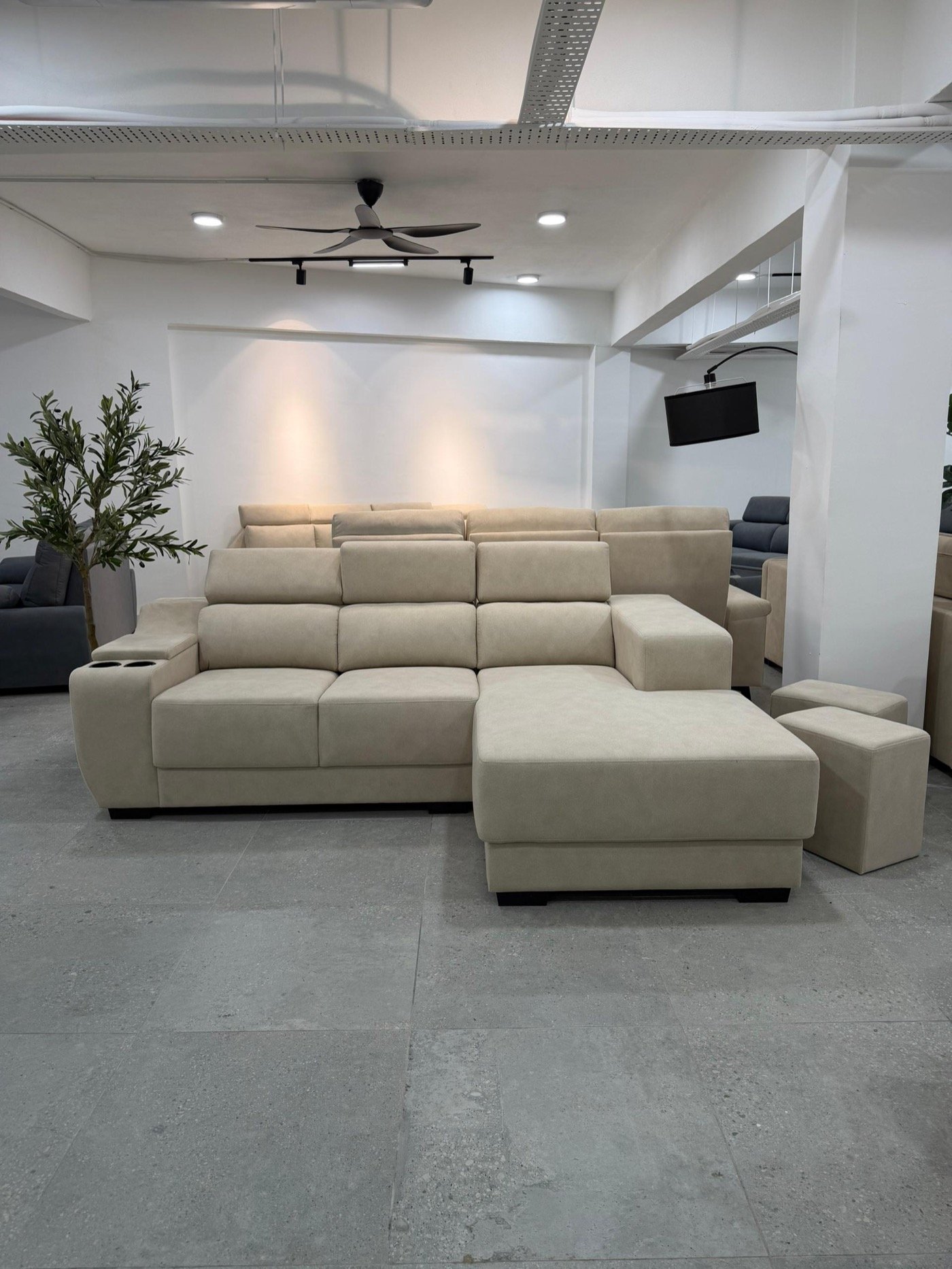 Beige L-shape sofa with adjustable headrests and matching stools on our Bukit Batok showroom floor