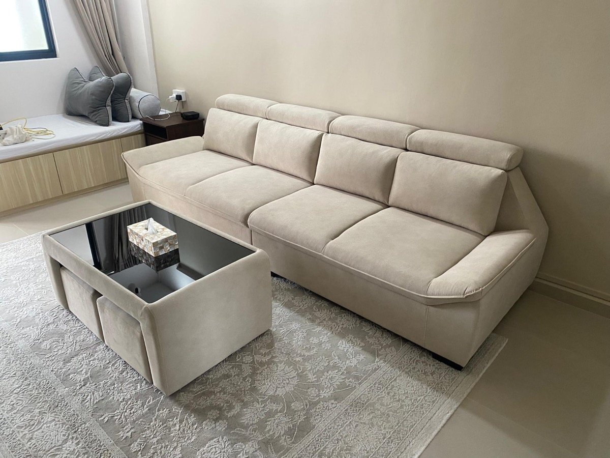 Beige four-seater sofa with headrests and glass coffee table installed in a customer's living room