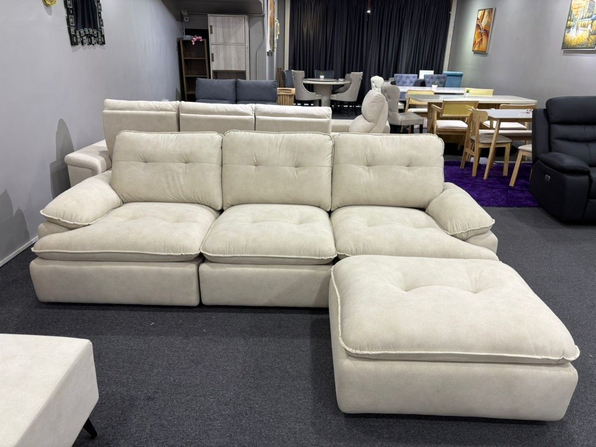 Model 3689 cloud-style sofa in beige with tufted cushions and movable ottoman on the showroom floor